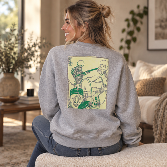 Model wearing the Happy Halloween crewneck in athletic heather, seated, back view showing the cream panel with green skeleton guitarist line art