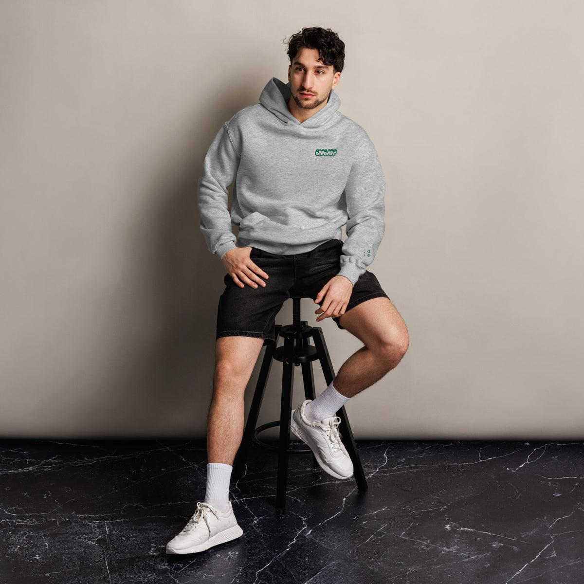 LVL UP unisex oversized hoodie in athletic heather, front view on a men's lifestyle model (Printful mockup)