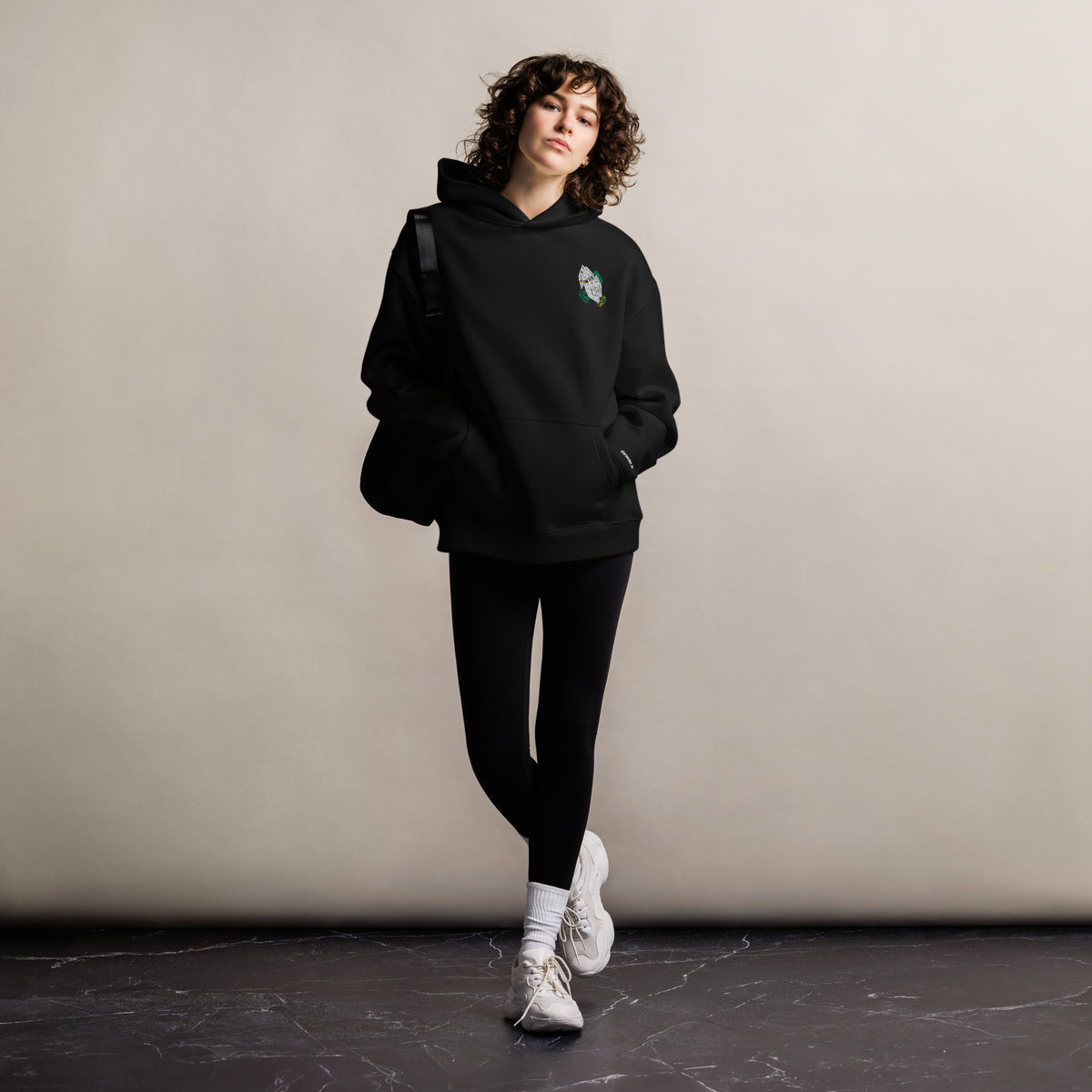 Pray For Me unisex oversized hoodie in black, front view on a women's lifestyle model (Printful mockup)