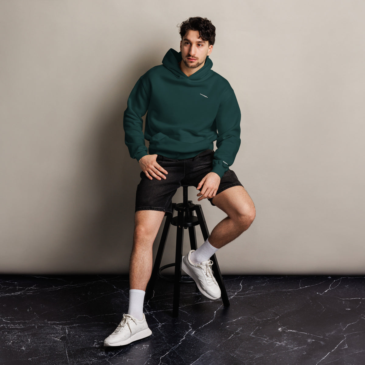 H?rd Day unisex oversized hoodie in pine green, front view on a men's lifestyle model (Printful mockup)