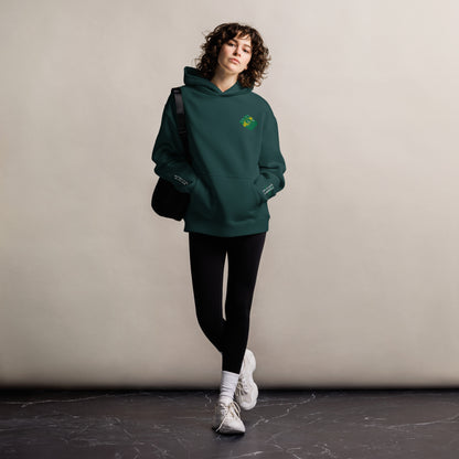Mickey Money '22 unisex oversized hoodie in pine green, front view on a women's lifestyle model (Printful mockup)